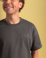 Man wearing a dark gray t-shirt with 'SMOSH' logo on a yellow background