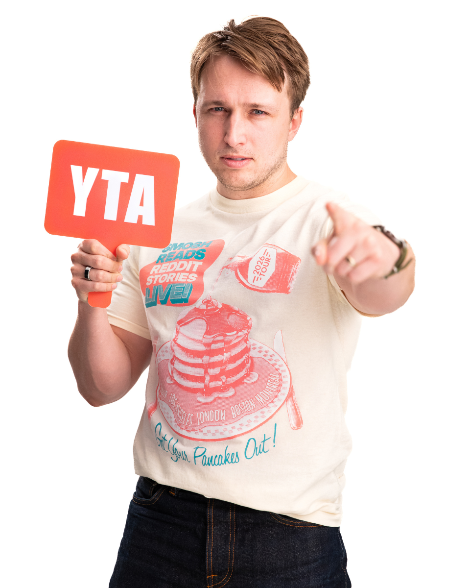 Person wearing a t-shirt with a graphic design and holding an 'YTA' sign.