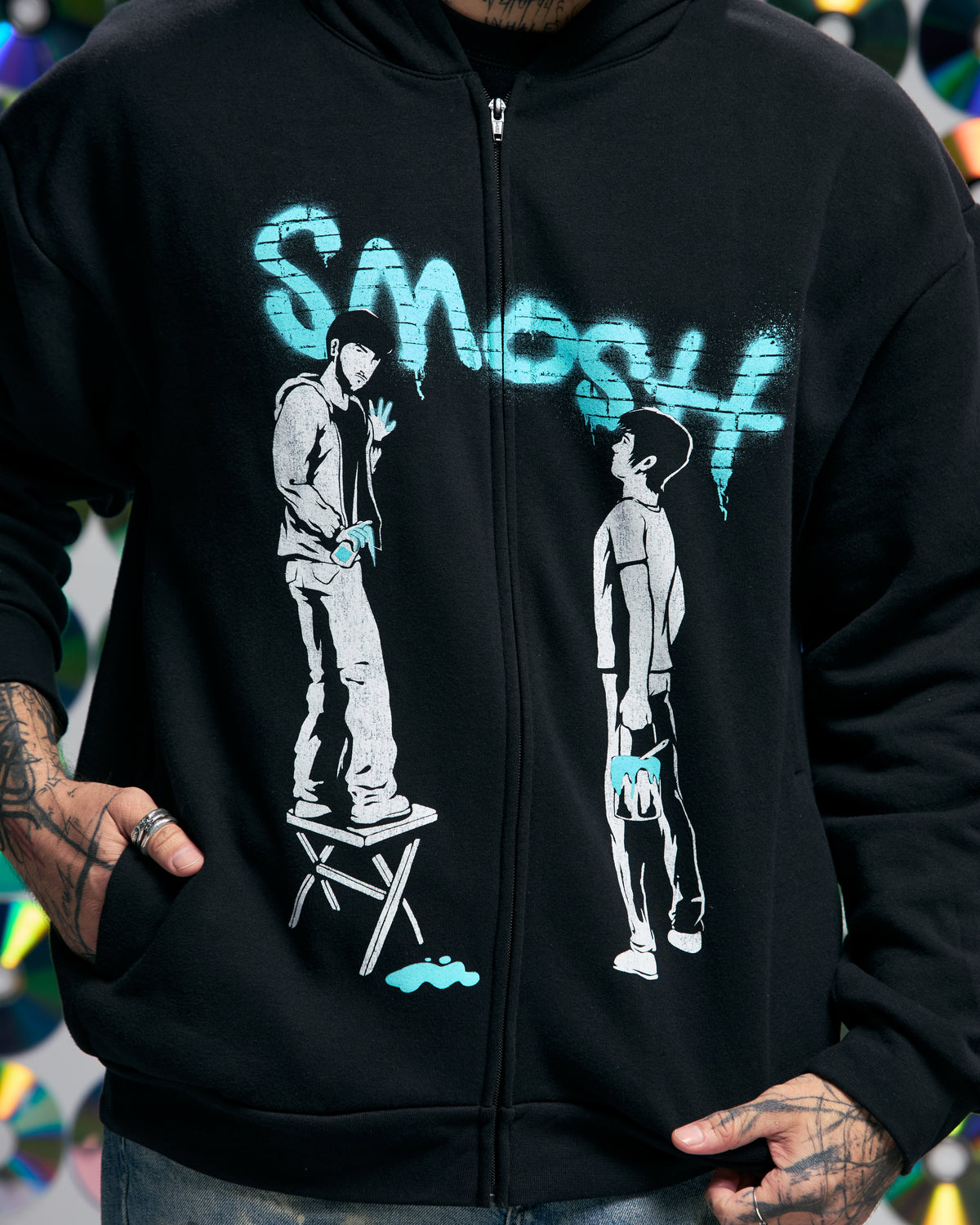 Black hoodie with graphic design and 'Smosh' text worn by a person.