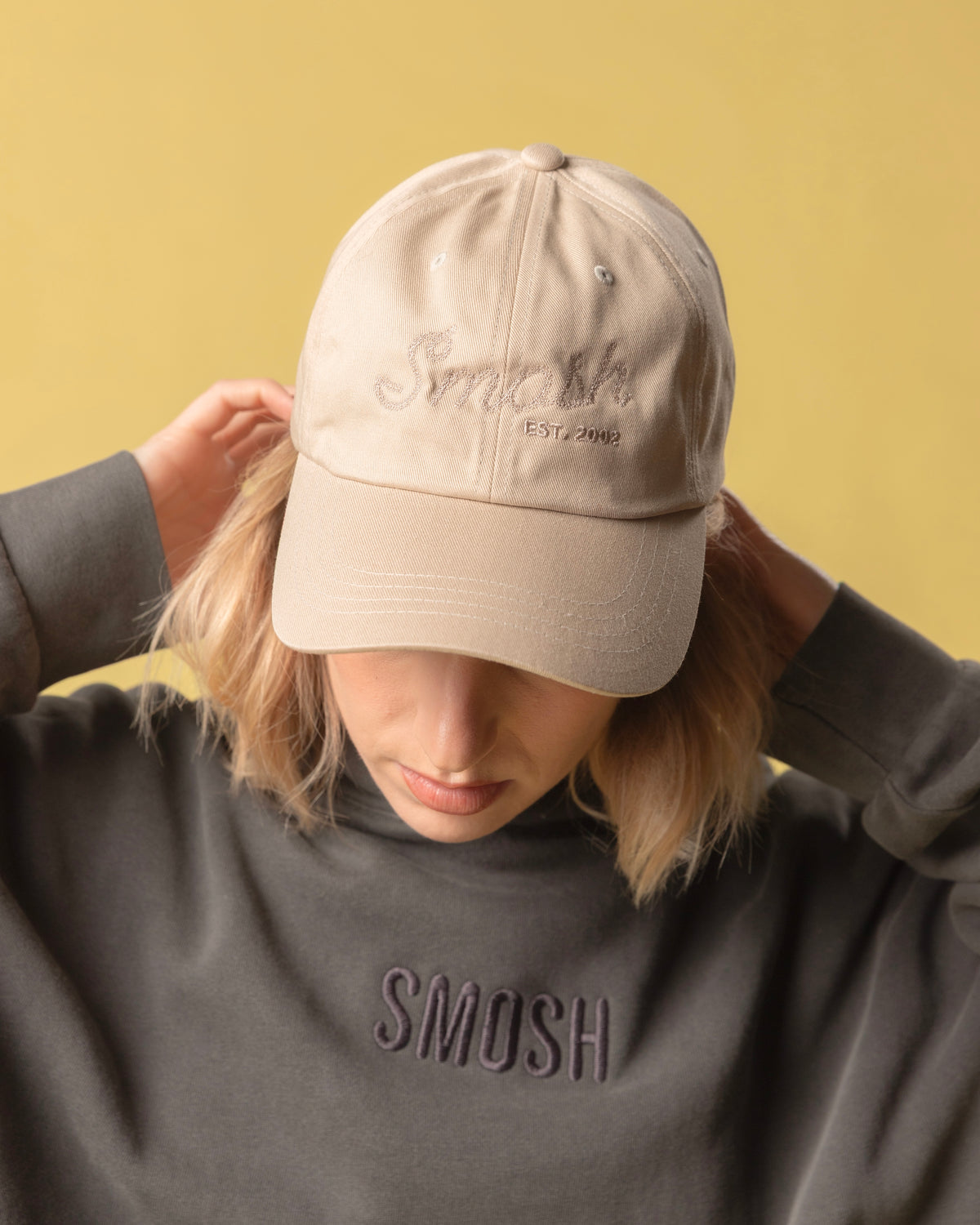 girl wearing cream colored hat that says smosh est. 2002