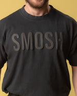 Person wearing a black sweatshirt with 'Smosh' text on a yellow background.