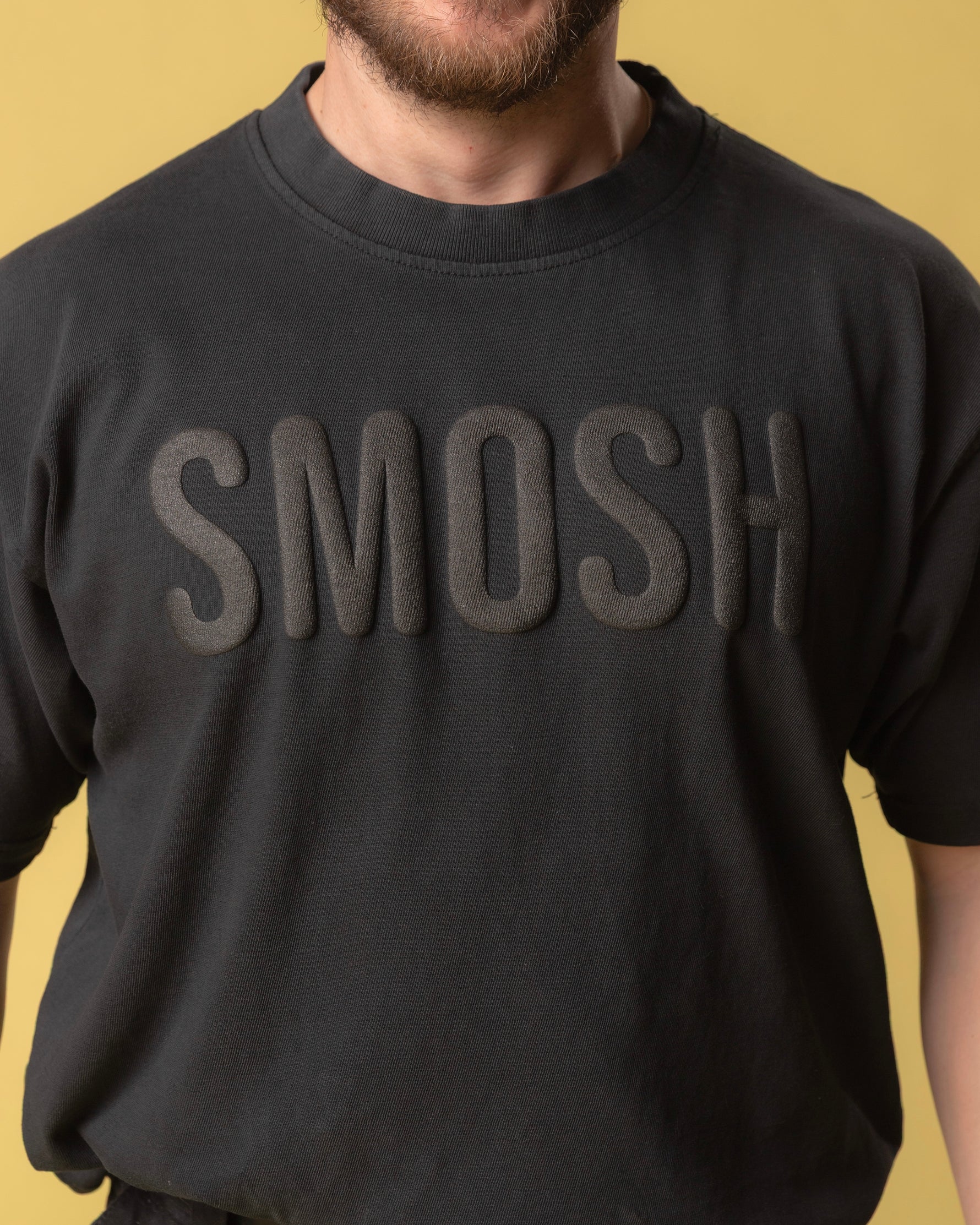 Person wearing a black sweatshirt with 'Smosh' text on a yellow background.