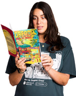 Woman holding a book titled 'Dread' while wearing a t-shirt with graphic designs.