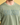 Person wearing a green t-shirt with 'Smosh' printed on it against a yellow background