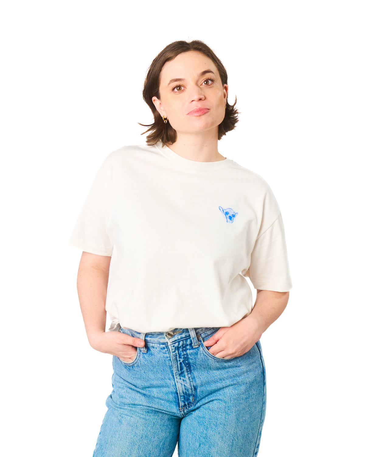 Person wearing a white t-shirt with a small blue dog logo and blue jeans on a white background