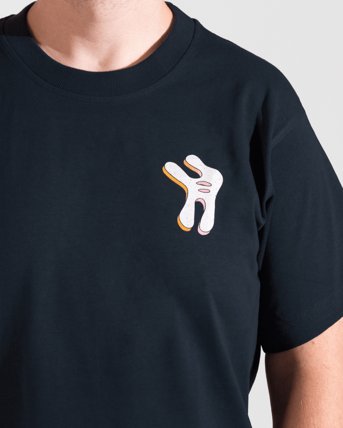 model wearing navy tshirt with funky multicolor smosh design on front on a white background