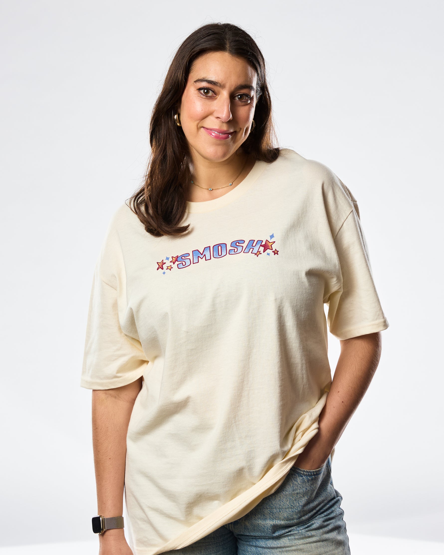 woman wearing a cream colored tshirt with smosh written on the front with stars 