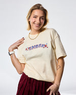 Woman wearing a cream t-shirt with 'SMOSH' text and stars on a white background