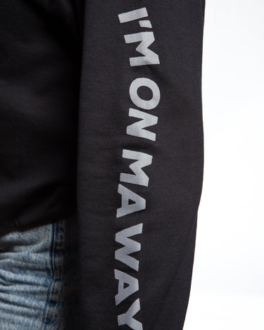 Close up sleeve logo of SMOSH black long sleeve Gerald Cakes Crewneck