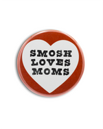 Heart-shaped button with 'Smosh Loves Moms' text on a white background